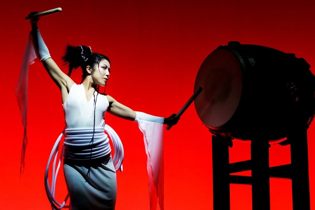 Drum Tao performer and a drum on a red background