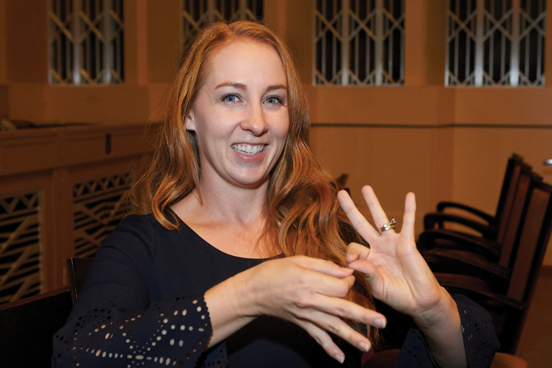 A photo of a woman doing sign language.