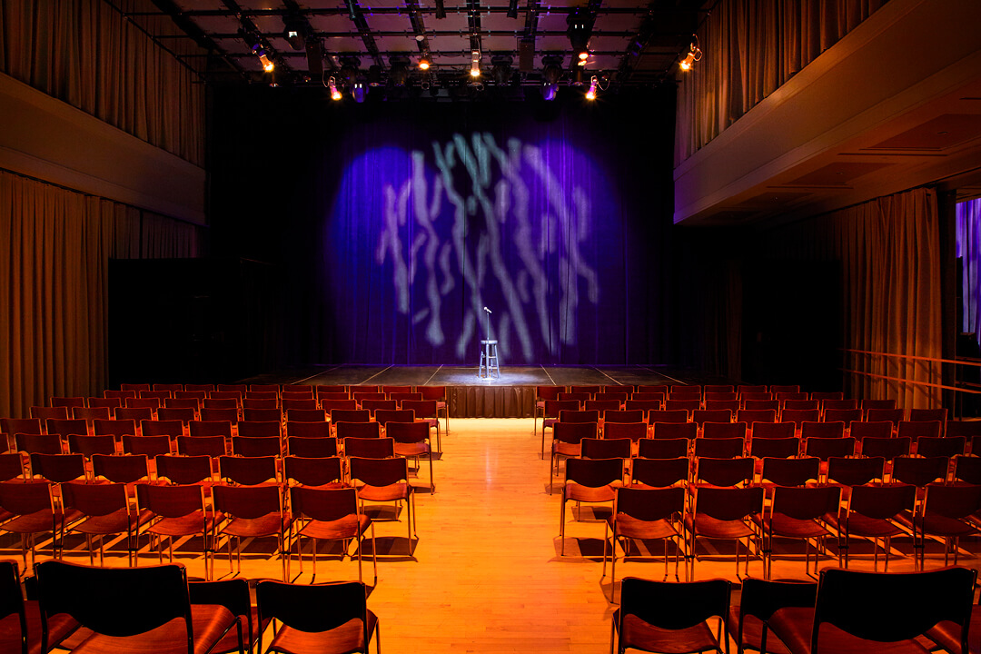 A photo of Troesh Studio Theater with chairs and a microphone