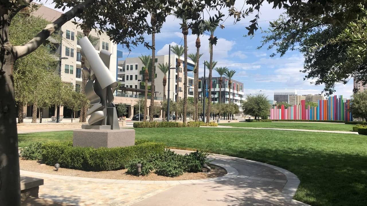 A photo of Symphony Park with apartment buildings in the back and a sculpture in the foreground. 