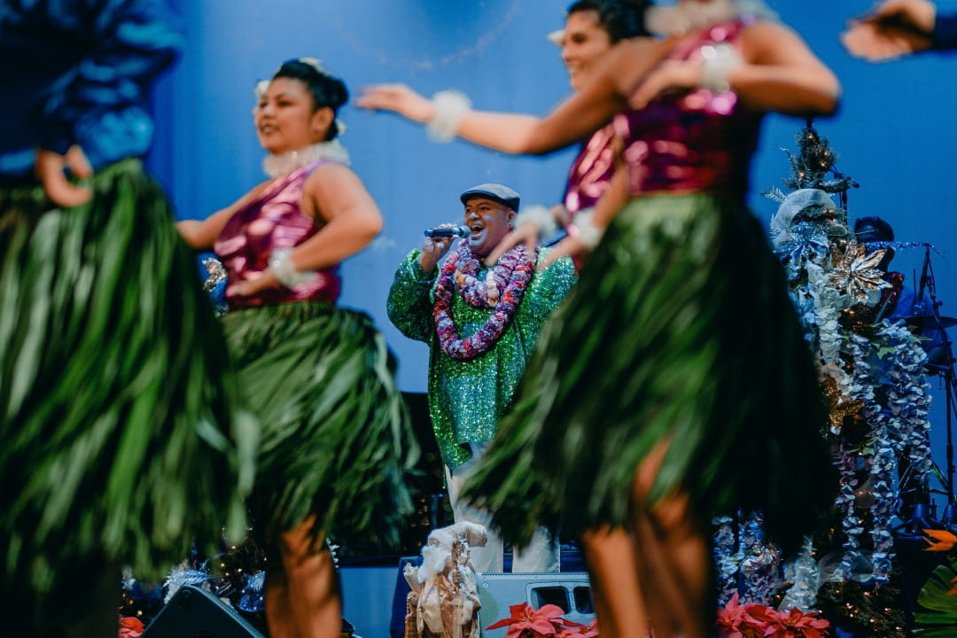 Kalani Pe'a singing with hula dancers