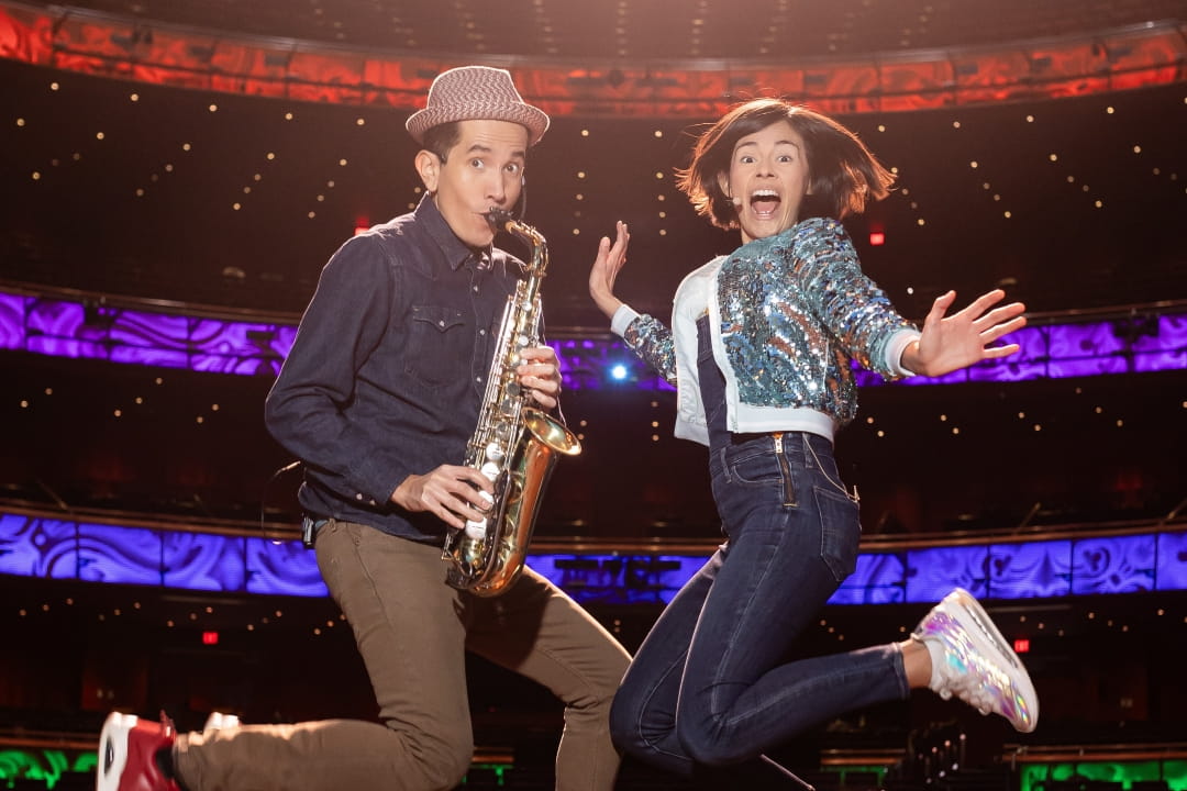 123 Andrés performing on stage with a saxophone